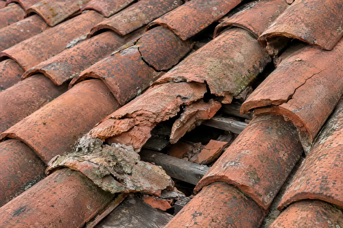 Prasklé a drolící se pálené tašky, u kterých je nutná výměna krytiny
